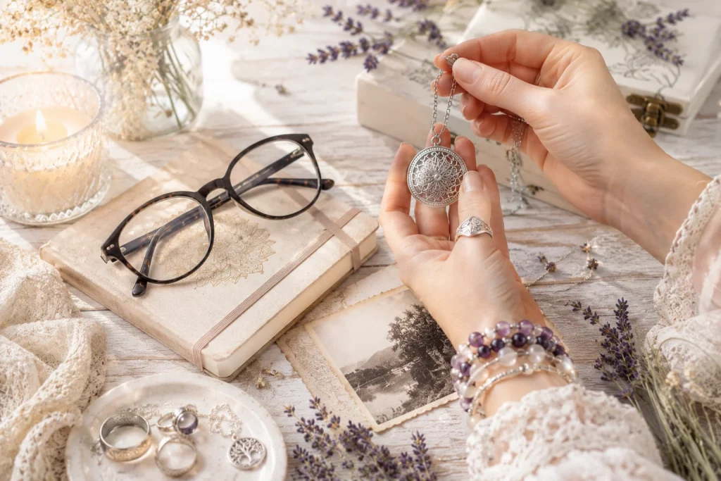 Hands holding a silver pendant while practising psychometry, reading energy from a personal object to develop psychic abilities and intuition.